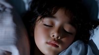 Young Asian child sleeping peacefully in bed with soft natural lighting, closed eyes and serene expression showing peaceful slumber and sweet dreams.