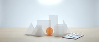 Geometric white shapes and orange sphere arranged on wooden surface with clipboard and pen for business planning and design concepts.