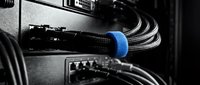 Network cables connected to server equipment with blue cable management ring for organized data center infrastructure and IT connectivity solutions.