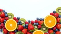 Fresh mixed berries and citrus fruits border on white background with strawberries, blueberries, raspberries, kiwi and orange slices for healthy eating.