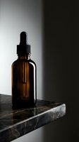 Amber glass dropper bottle with black cap on dark marble surface, minimalist studio lighting for skincare, cosmetics, essential oils, serums, and pharmaceutical product packaging design.