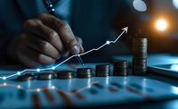 African American businessman analyzing financial growth chart with stacked coins showing increasing profit trend in dark office with ambient lighting.