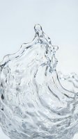 Clear water splash with dynamic flowing motion and crystalline droplets frozen in mid-air against white background, isolated for design and advertising use.