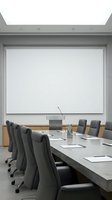 Modern conference room with blank projection screen, concrete table, gray office chairs, and minimalist design for corporate presentations and business meetings.