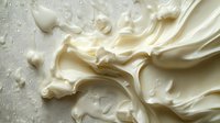 Creamy white liquid splash with dynamic flowing motion and droplets on textured surface for food and beverage advertising campaigns.