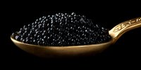 Black caviar on vintage golden spoon against dark background, luxury gourmet food close-up. Elegant appetizer presentation highlights delicate texture of sturgeon roe.