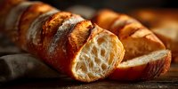 Freshly baked artisan bread loaf with golden crust sliced on wooden cutting board, showing airy texture and perfect crumb structure for bakery marketing.