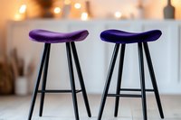 Modern bar stools with curved purple seats and black metal legs against blurred warm interior background, minimalist contemporary furniture design.