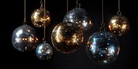 Shiny disco balls hanging against dark background, reflecting light in gold and silver tones for nightclub, party, or celebration atmosphere.