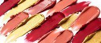 Colorful lipstick smears in red, pink, coral and gold tones creating artistic makeup texture pattern on white background for beauty and cosmetics design.