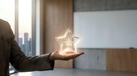 Professional businessman holding glowing star symbol in modern office representing success, achievement and excellence in corporate environment.