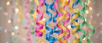Colorful party streamers and ribbons hanging with bokeh lights background for celebration, birthday, festive decoration and holiday events.