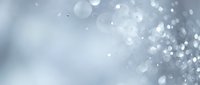 Soft gray bokeh background with floating white light particles and gentle blur effects for elegant design projects and presentations.