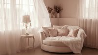 Cozy living room interior with soft pink walls, cream curved sofa draped with knit blanket, side table with crystal lamp, sheer curtains, and dried flowers for home decor inspiration.