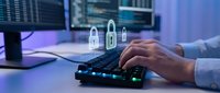 Businessman typing on keyboard with digital security padlock icons floating above, representing cybersecurity and data protection in modern office environment.