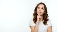 Young brunette woman in white t-shirt looking up thoughtfully with hand on chin, contemplating ideas against clean background for business content.