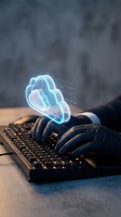 Hands typing on keyboard with glowing cloud hologram representing cloud computing, data storage, and digital technology solutions for modern business.
