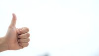 Hand showing thumbs up gesture on white background expressing approval and positive feedback for business success concepts.