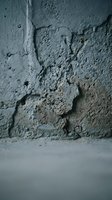 Weathered concrete wall with deep cracks, peeling texture, and crumbling surface showing age and deterioration. Suitable for backgrounds, construction, urban decay, and architectural projects.