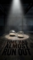 Hourglass lying on its side on a wooden surface under dramatic spotlight with bold text Time Has Almost Run Out in dark moody setting.