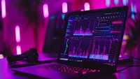 Gaming laptop displaying analytics dashboard with neon pink ambient lighting and glowing keyboard, creating futuristic cyberpunk atmosphere in dark room.