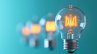 Glowing vintage light bulb with filament on turquoise background with blurred bulbs. Creative innovation and energy concept for business solutions.