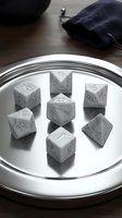 Polyhedral dice set in white marble finish arranged on illuminated circular display with dark fabric pouch, tabletop gaming accessories for role-playing games.
