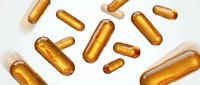 Golden vitamin capsules scattered on white background, pharmaceutical supplements for health and wellness, isolated design elements for medical content.