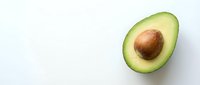 Fresh avocado half with pit on clean white background, isolated organic fruit for healthy cooking and nutrition concepts.