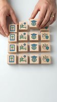 Hands arranging wooden blocks with healthcare icons including medical symbols, hospital beds, and health shields on white background for medical concepts.