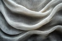 Elegant white fabric with gentle waves and folds creates abstract flowing lines and textures against gray background, suitable for luxury fashion and interior design.
