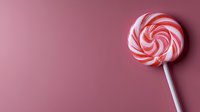 Round red and white striped lollipop candy on pink background with copy space. Minimalist sweet food composition for confectionery and dessert designs.