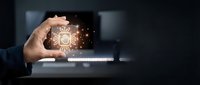 Businessman hand holding tablet displaying glowing artificial intelligence circuit board icon with light effects, representing digital innovation and technology solutions.