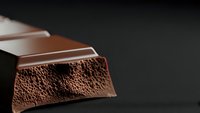 Milk chocolate bar pieces with aerated bubbly texture on dark background for confectionery and dessert advertising campaigns.
