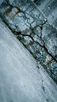 Weathered concrete surface with deep cracks and rust stains showing urban decay and deterioration for construction and renovation projects.