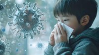 Young Asian boy wearing sweater blows nose in tissue while virus particles float in air, representing cold and flu season health concept in blue tones.