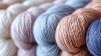 Colorful yarn skeins in soft pastel tones arranged for knitting and crochet projects. Crafting supplies for handmade textile creation and hobby activities.