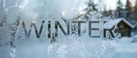 Frost-covered window with the word Winter etched in ice crystals, snowy forest and wooden cabin visible in the blurred background.