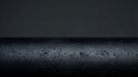 Dark concrete surface with water droplets and moody atmospheric lighting for modern industrial design backgrounds.