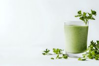 Fresh green smoothie with parsley garnish in glass on white background, healthy detox drink for wellness and weight loss programs.