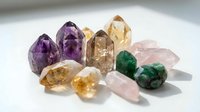 Collection of natural healing crystals including amethyst citrine rose quartz and malachite gemstones arranged on white background for meditation wellness.