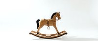 Vintage wooden rocking horse with dark mane and leather saddle, isolated on white background, evoking childhood nostalgia and classic toy craftsmanship.
