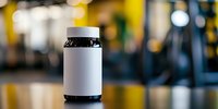 White supplement bottle with black cap on blurred gym background for fitness nutrition and health product marketing.