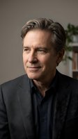 Middle-aged Caucasian man with gray-streaked hair wearing charcoal blazer and navy shirt, suitable for corporate portraits, business headshots, and professional profiles.