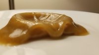 Carved amber or resin sculpture of a reclining figure with smooth, polished surface displayed on white background, suitable for art, antiques, collectibles, and decorative design projects.