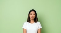 Young woman with long dark hair and East Asian ethnicity wearing a white t-shirt against a soft green background, suitable for casual lifestyle, fashion, and portrait projects.