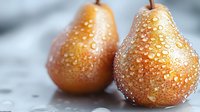 Fresh ripe pears with water droplets on golden skin, showcasing natural texture and juicy appearance for food photography and culinary design.