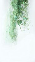 Green glitter and sparkle particles dispersing and dissolving on white isolated background, suitable for overlays, transitions, and digital design projects.