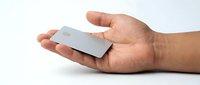 Hands holding silver credit card on white background for financial services, banking, payment solutions and e-commerce applications.