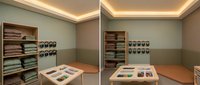 Modern fabric showroom interior with textile samples displayed on wooden shelves and tables. Professional retail space for interior design consultations.